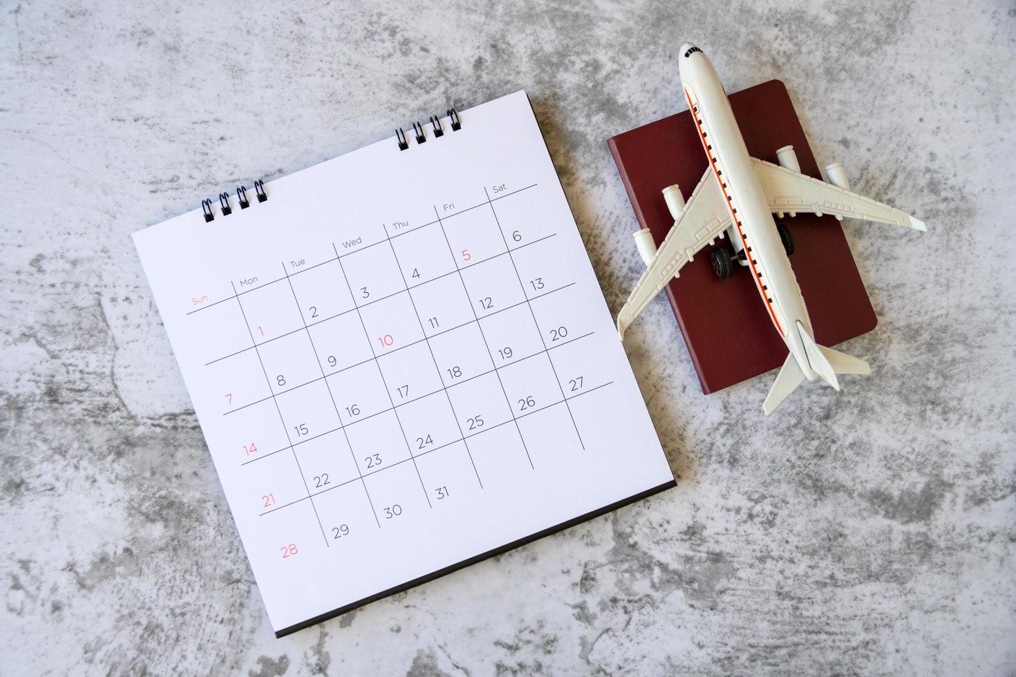 modelo de avión con calendario de papel. plan de viaje foto