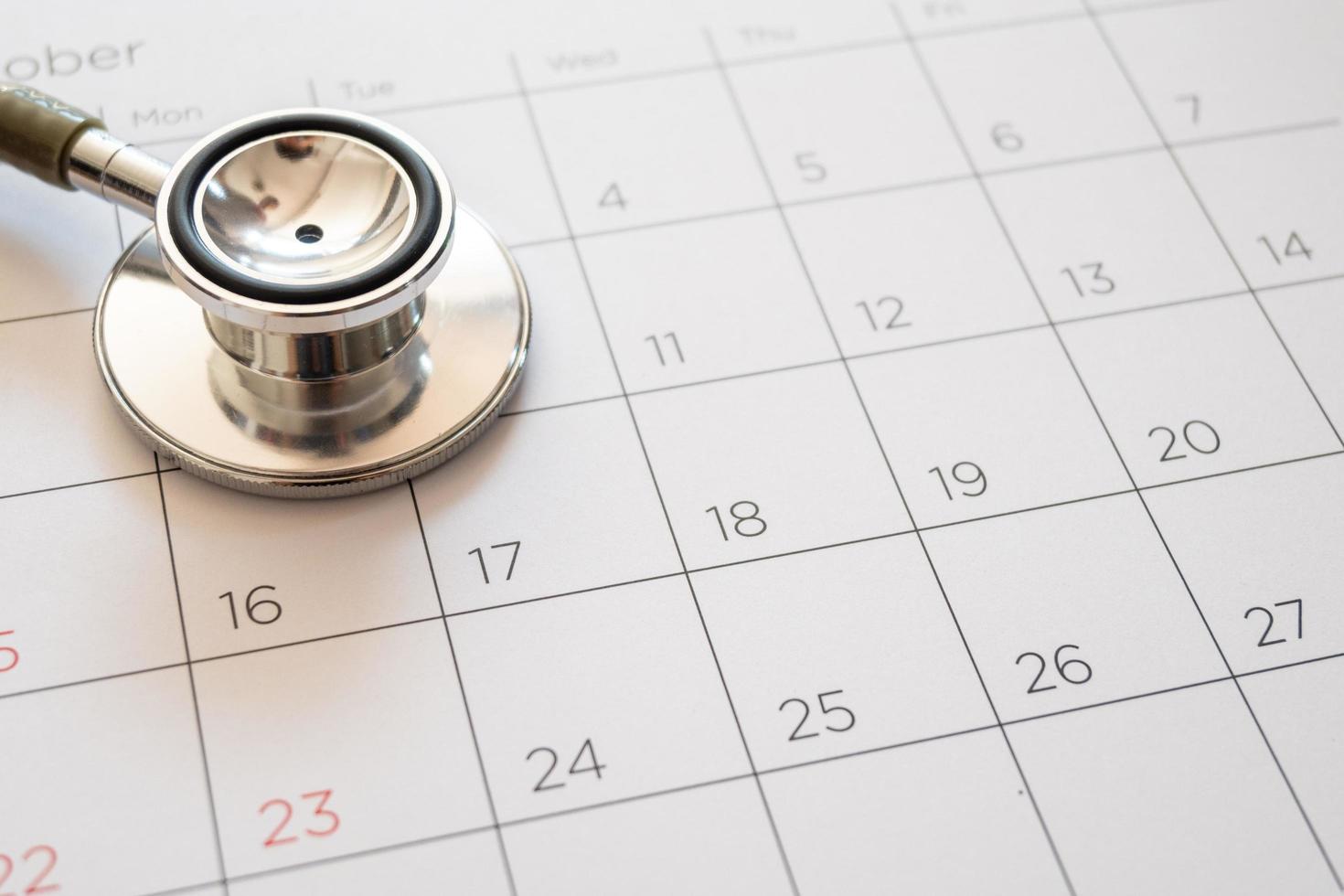 stethoscope and calendar on wooden table, schedule to check up healthy concept photo
