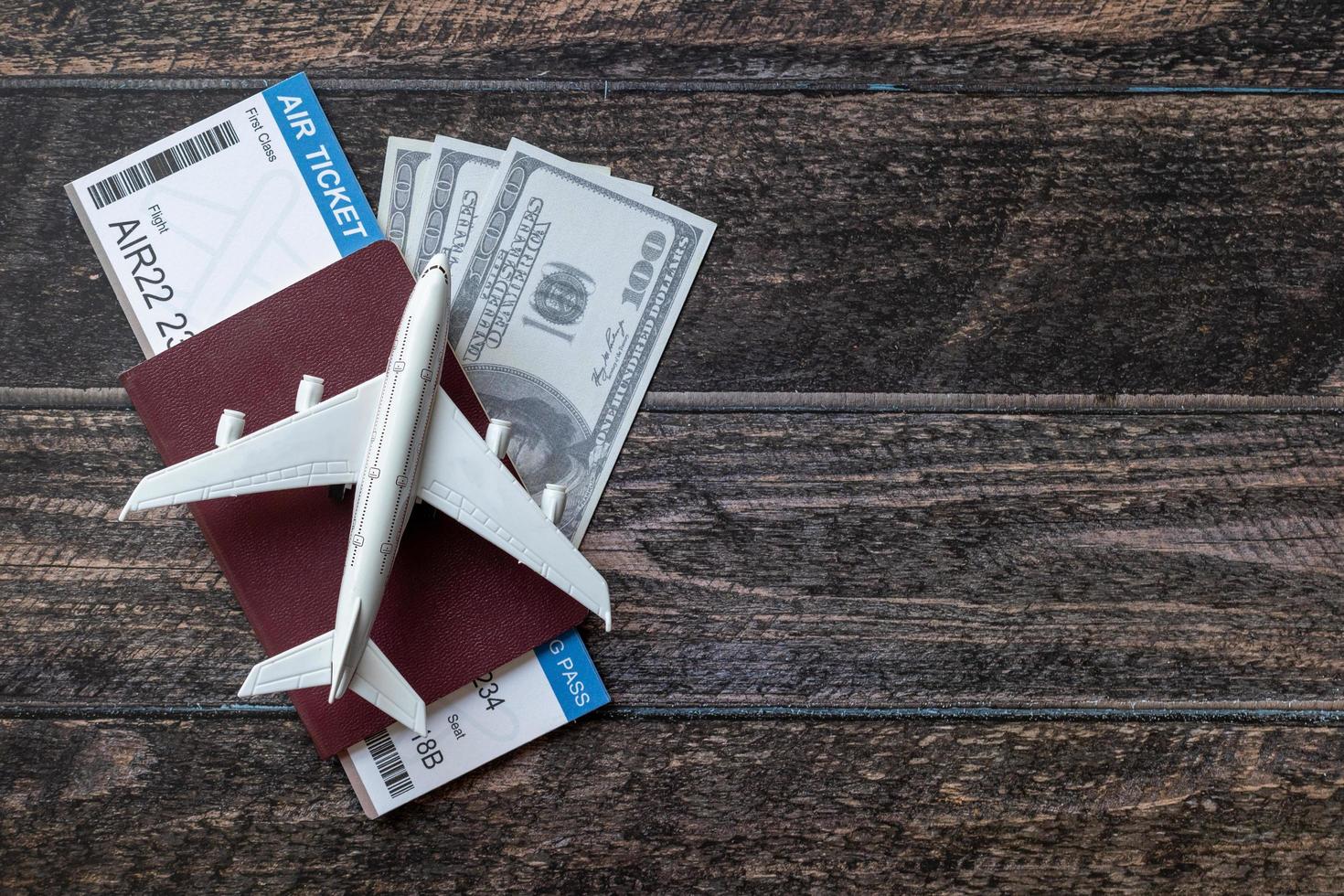 Toy airplane, Air Ticket, credit cards, dollars and passport on wooden table. Travel concept photo