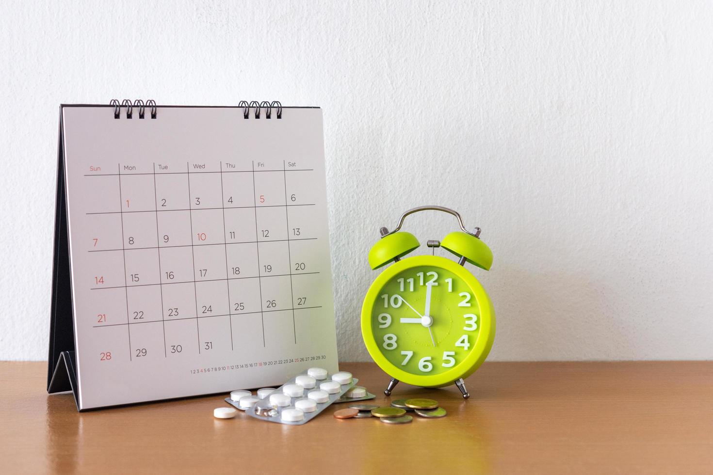 Calendar and drugs on table. photo