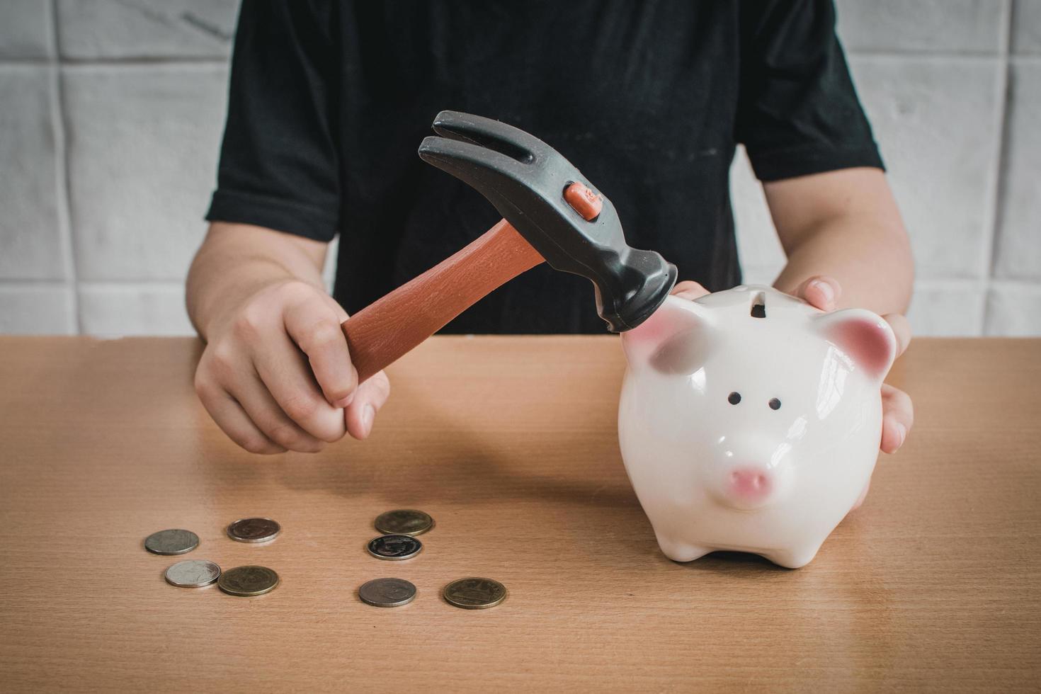 Little boy breaking a piggy bank photo