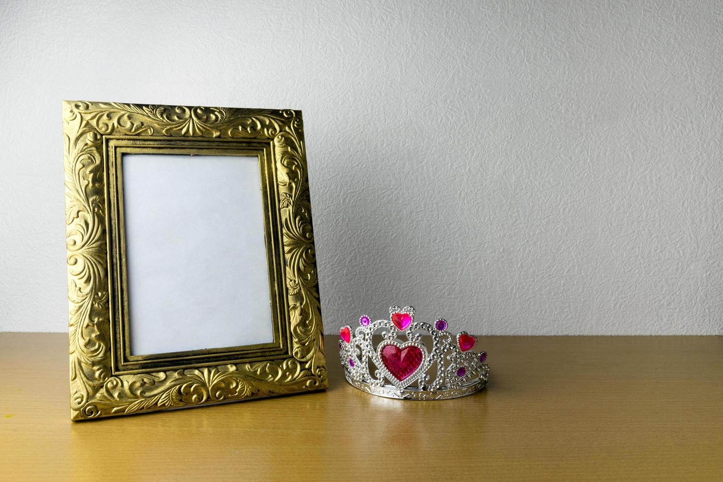 photo frame and crown on wooden table