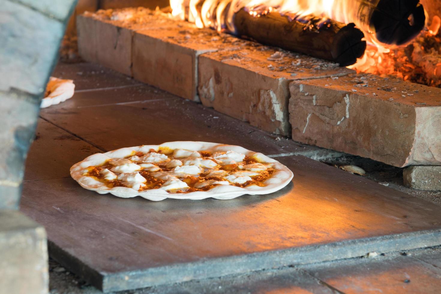 Pizza de masa fina horneada en horno de leña foto