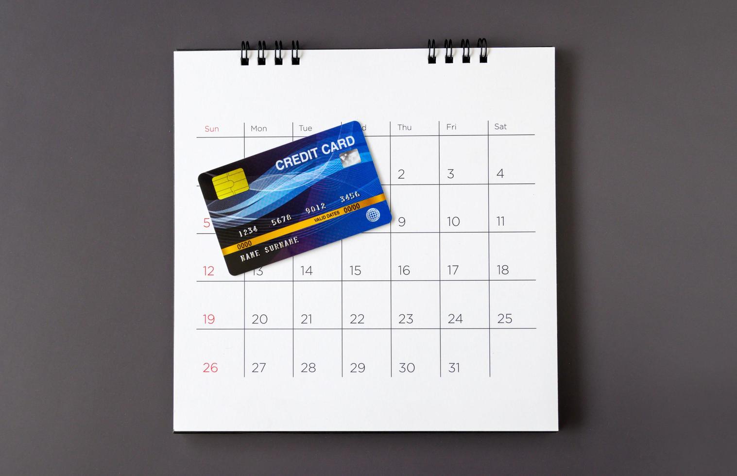 calendario con días y tarjeta de crédito en la mesa. concepto de compras foto