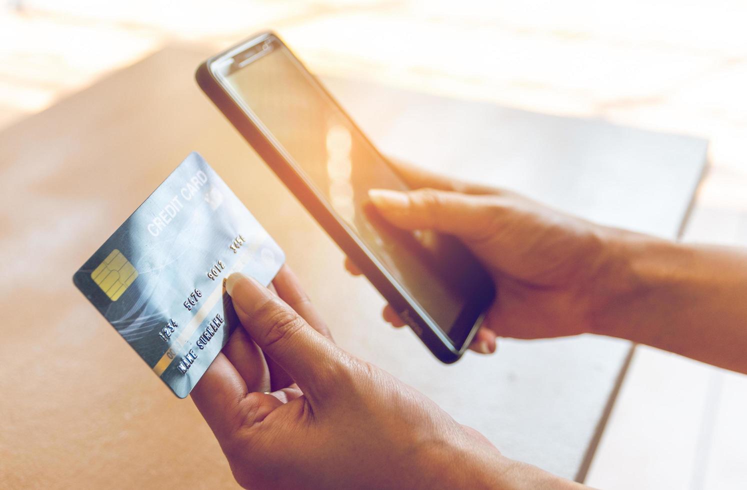 Woman holding credit card and smartphone. On-line shopping on the internet using a smartphone photo