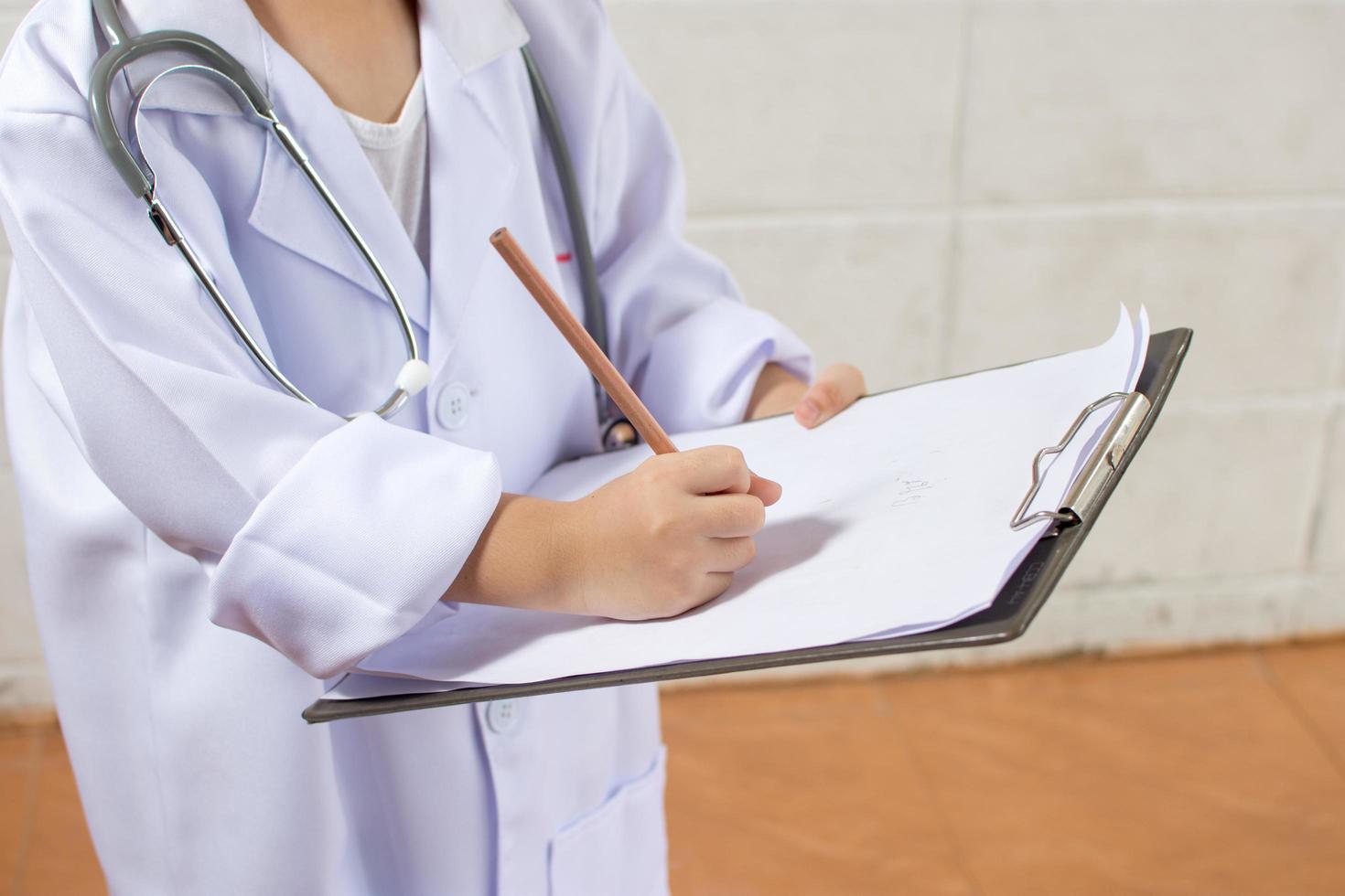 Asian girl wearing as a doctor writing prescription and preparing patients report photo