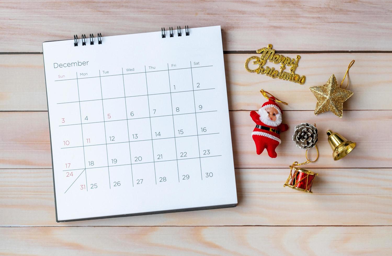 calendario de diciembre y decoración navideña - santa claus y regalo en mesa de madera. concepto de navidad y feliz año nuevo foto