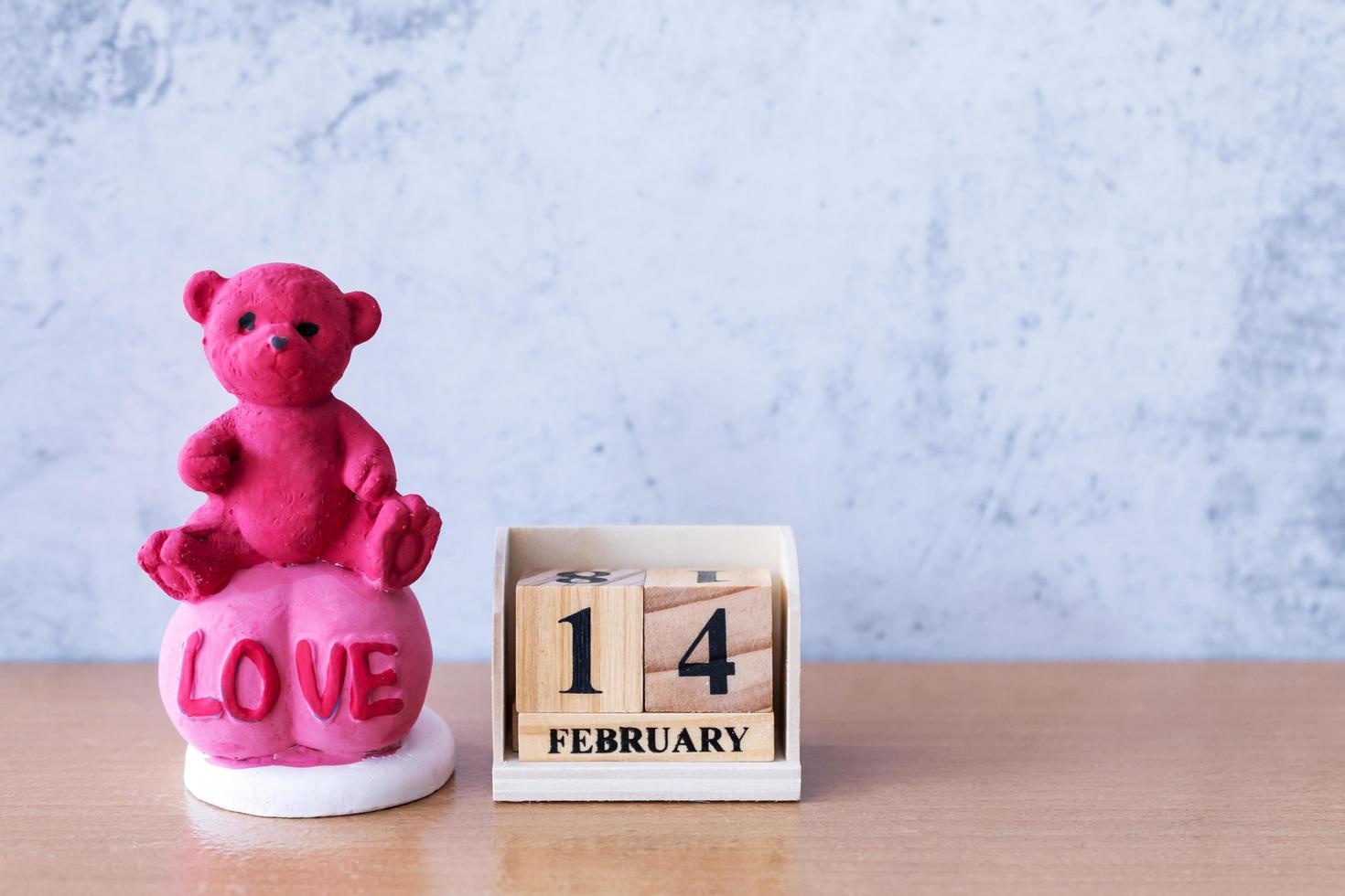 oso de peluche con calendario de madera 14 de febrero. día de San Valentín foto