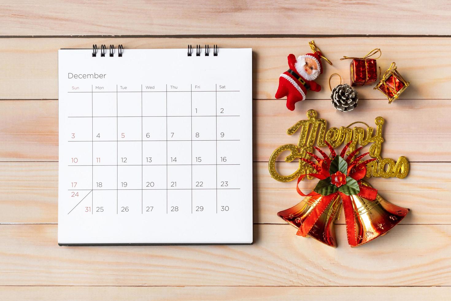 calendario de diciembre y decoración navideña - santa claus y regalo en mesa de madera. concepto de navidad y feliz año nuevo foto