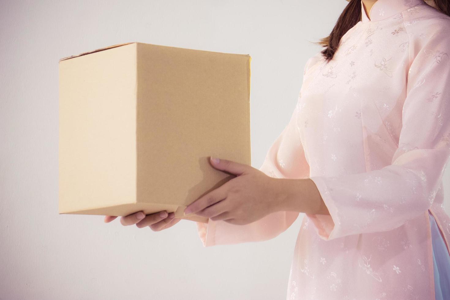 beautiful woman in pink dress and vietnam hat holding box photo