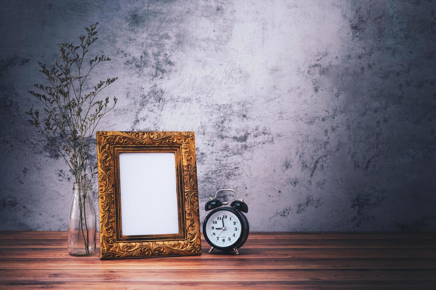 Picture frame and flowers and clock on wooden table. Poster product design styled photo