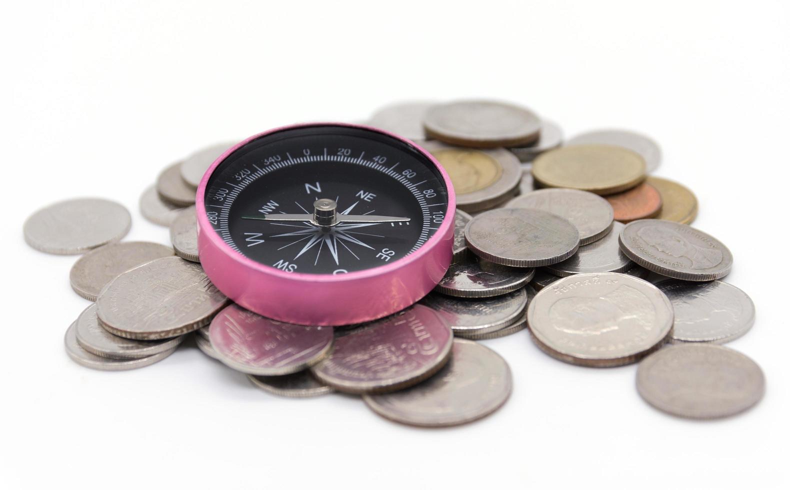 compass and coins on white background photo