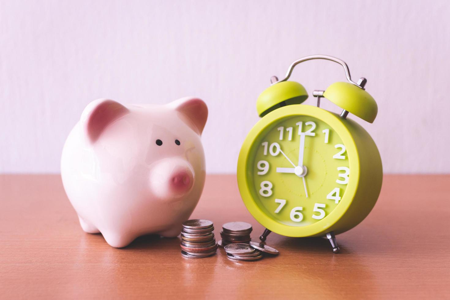 Piggy bank, alarm clock and coins. for growing business. time to saving concept. photo