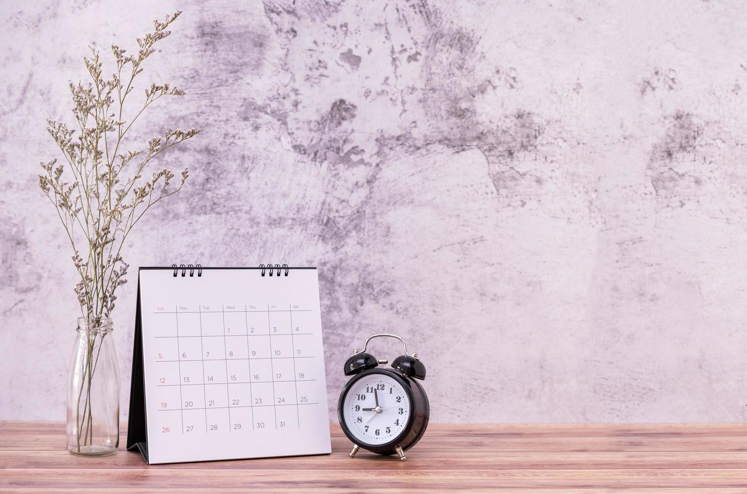 Picture frame and flowers and clock on wooden table. Poster product design styled photo