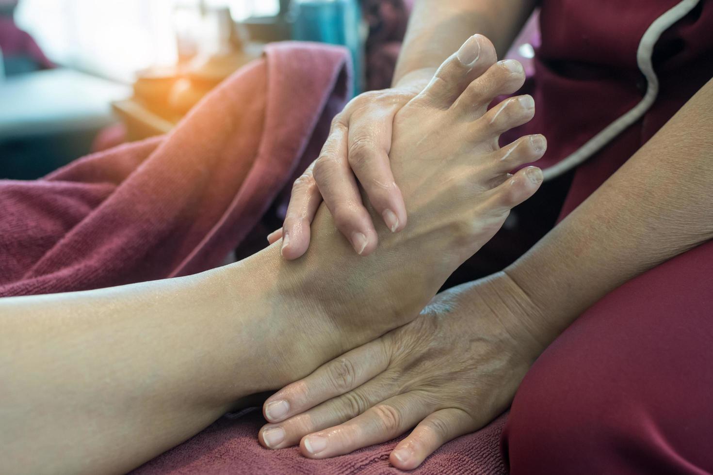 Woman receiving foot massage service from masseuse photo