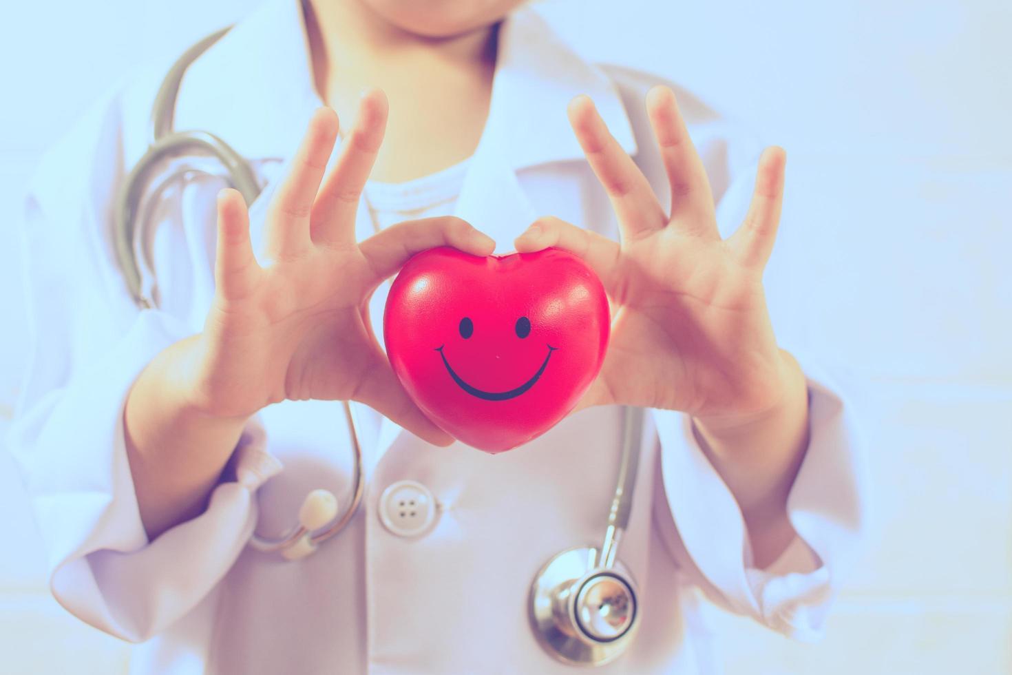 Asian girl playing as a doctor care healthy heart photo