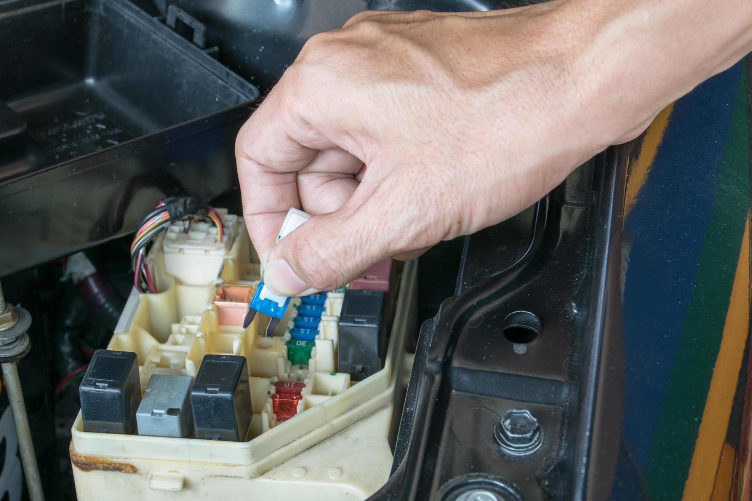 Mecánico de automóviles comprobando un fusible del coche foto