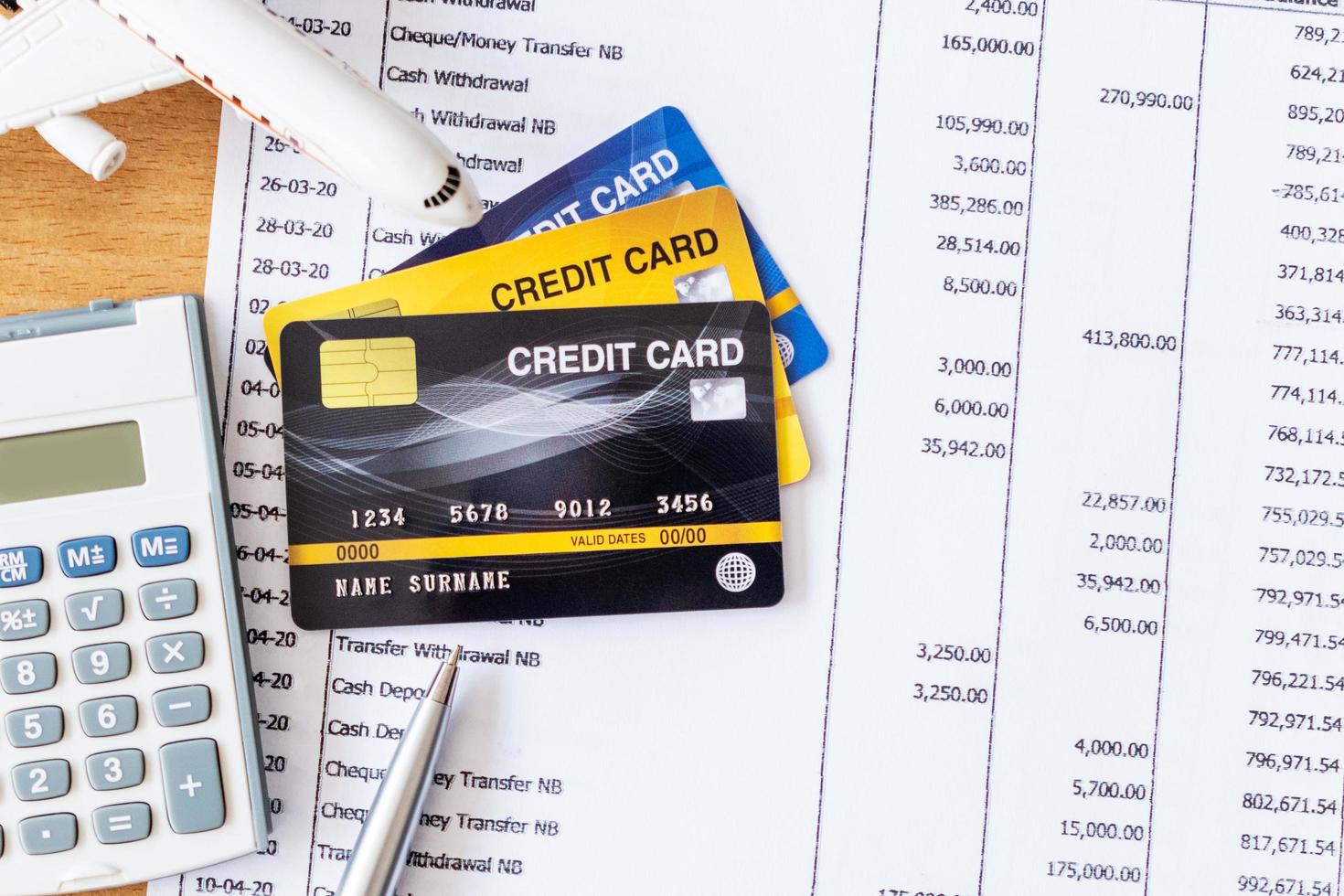 Airplane model and calculator on Bank statement and credit card on a Wooden table. Finance about Travel concept photo