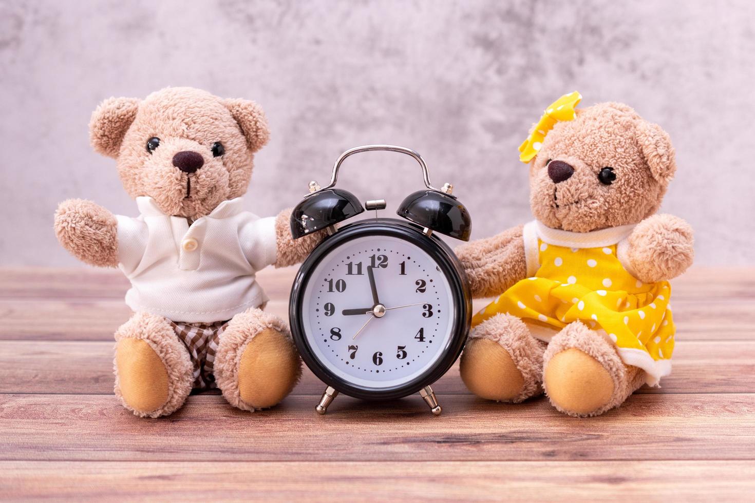 couple teddy bear and clock on table wooden. Valentine's Day celebration photo