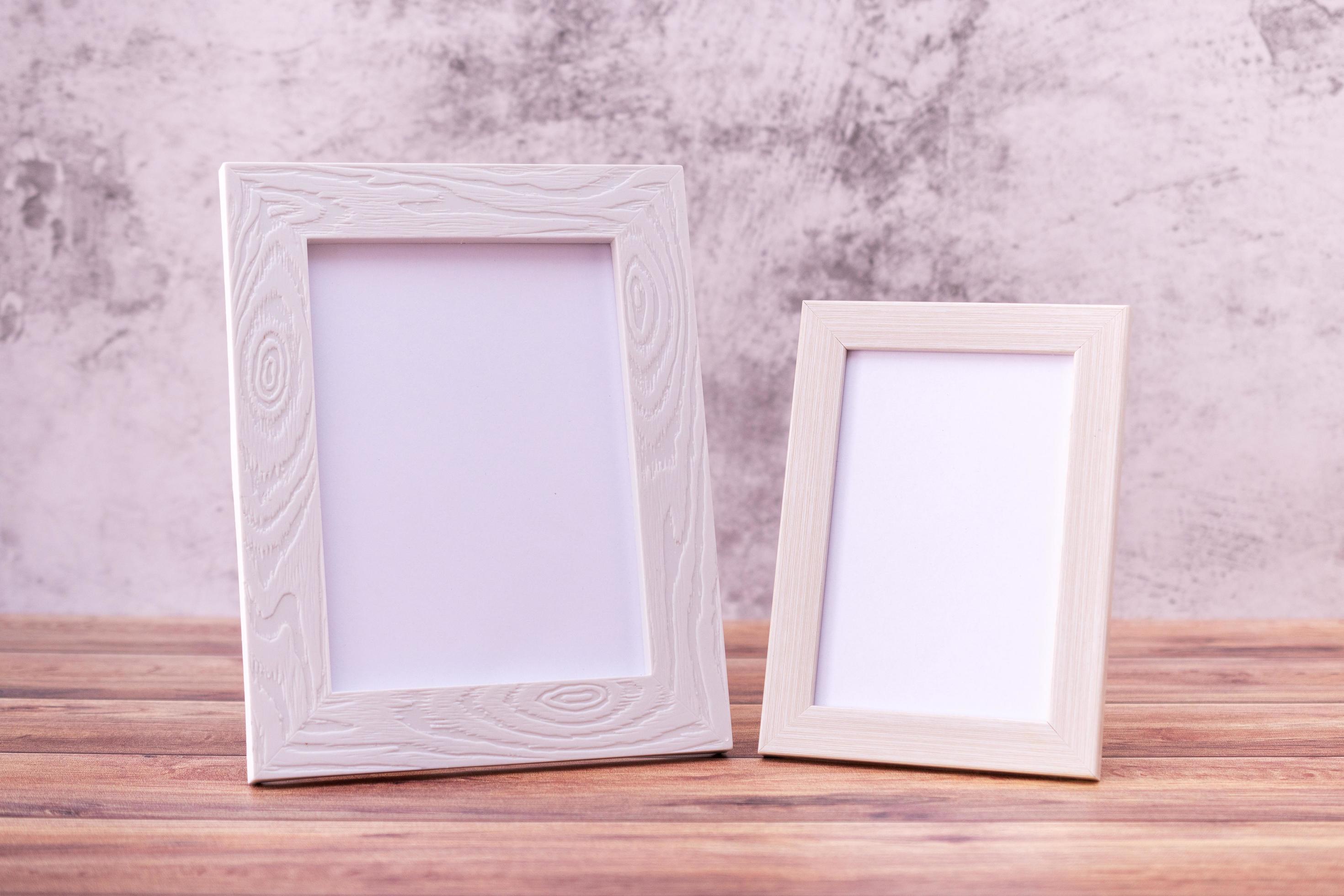 Two Picture frame on wall background and wooden table. Poster product