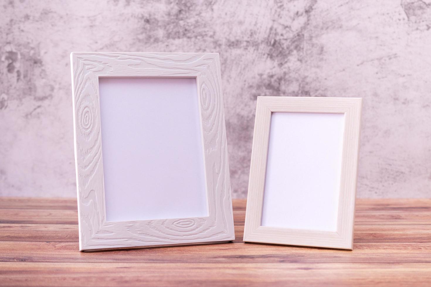 Two Picture frame on wall background and wooden table. Poster product design styled photo