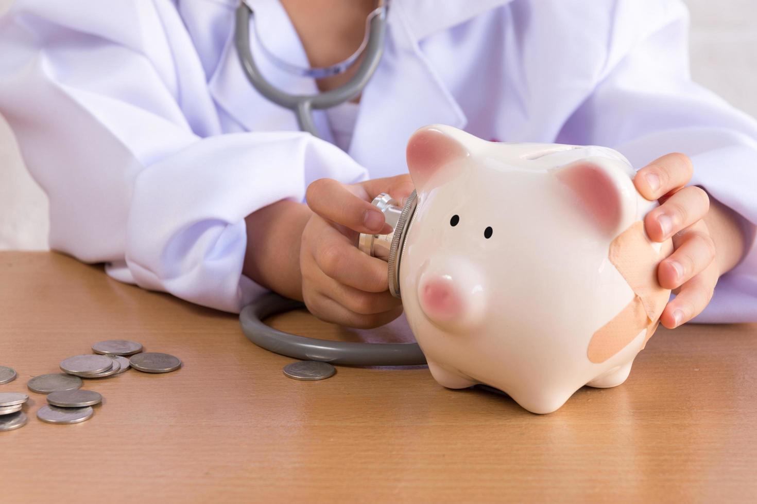 Asian girl playing as a doctor care Piggy Bank photo