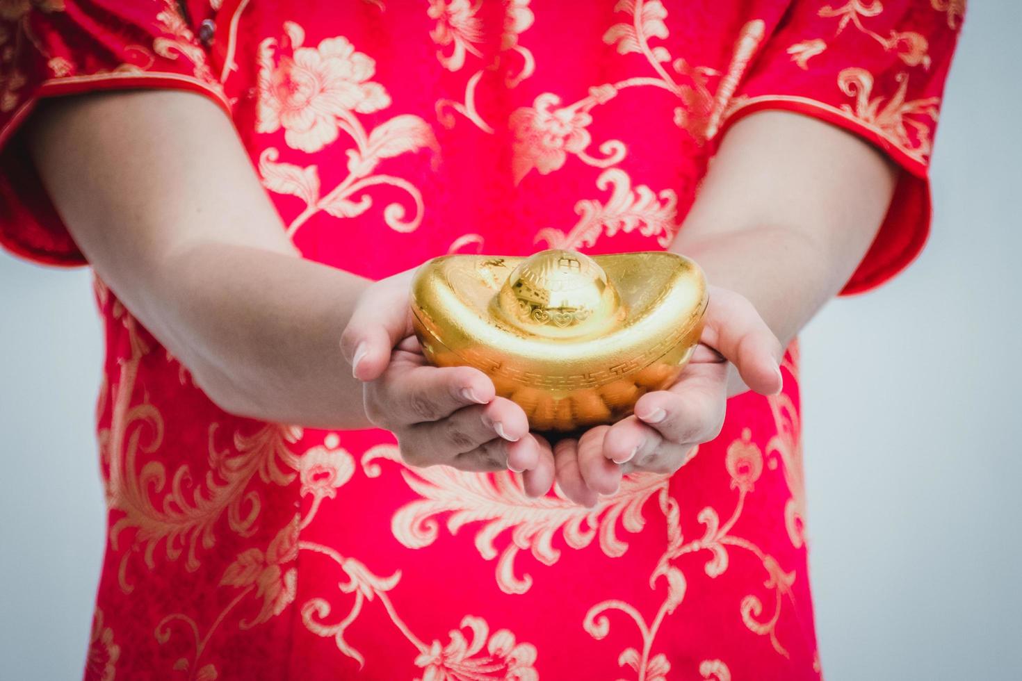 Asian woman with cheongsam holding gold. Chinese new year. photo