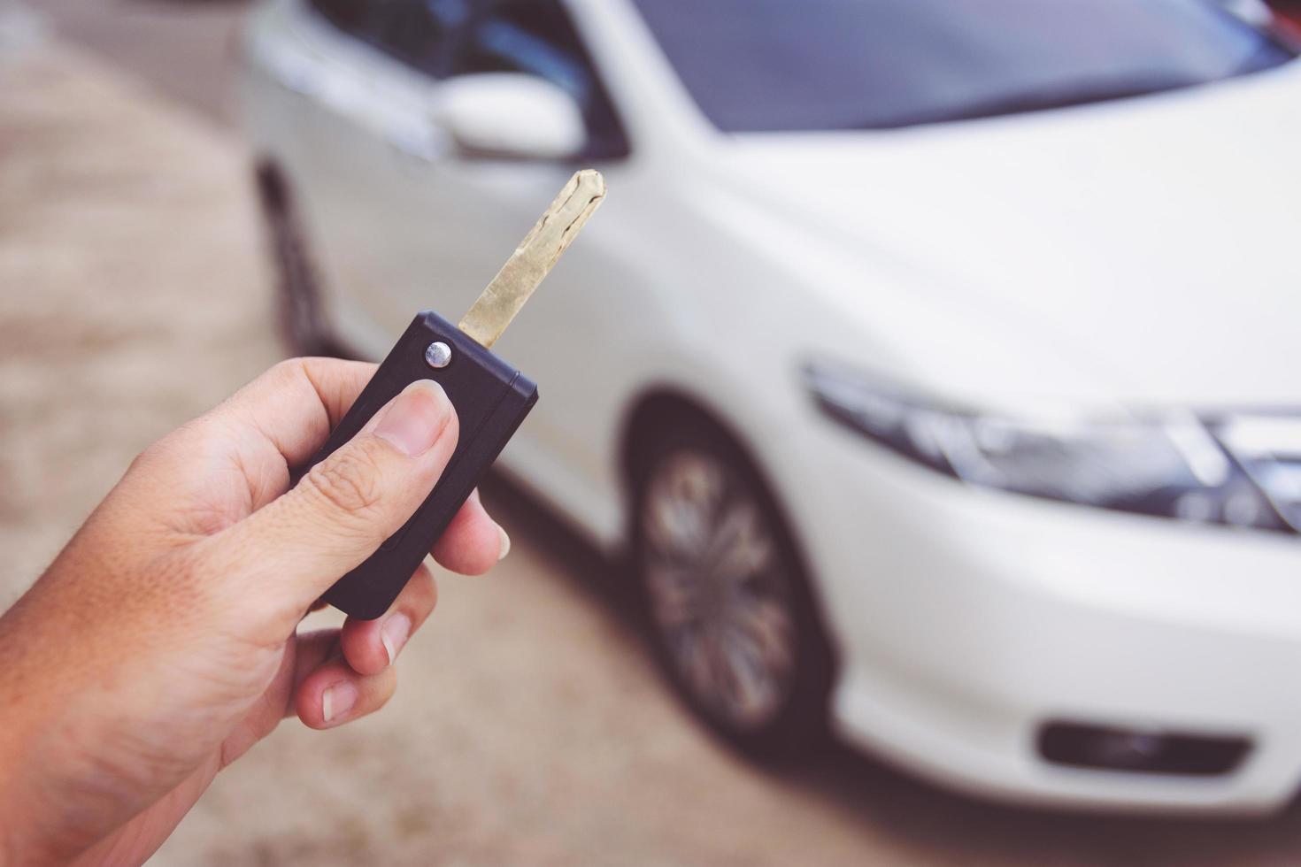 Man holding car keys with car on background photo