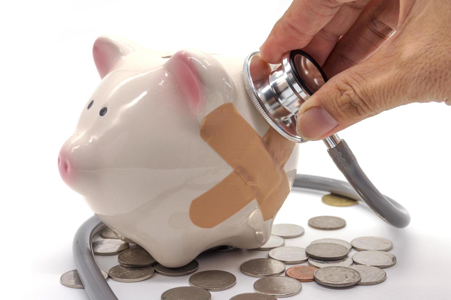 Doctor Holding Stethoscope to Piggy Bank photo
