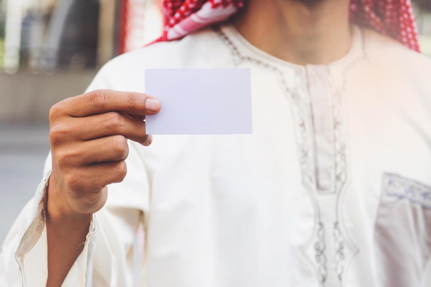 mano de hombre de negocios árabe que muestra la tarjeta de visita foto