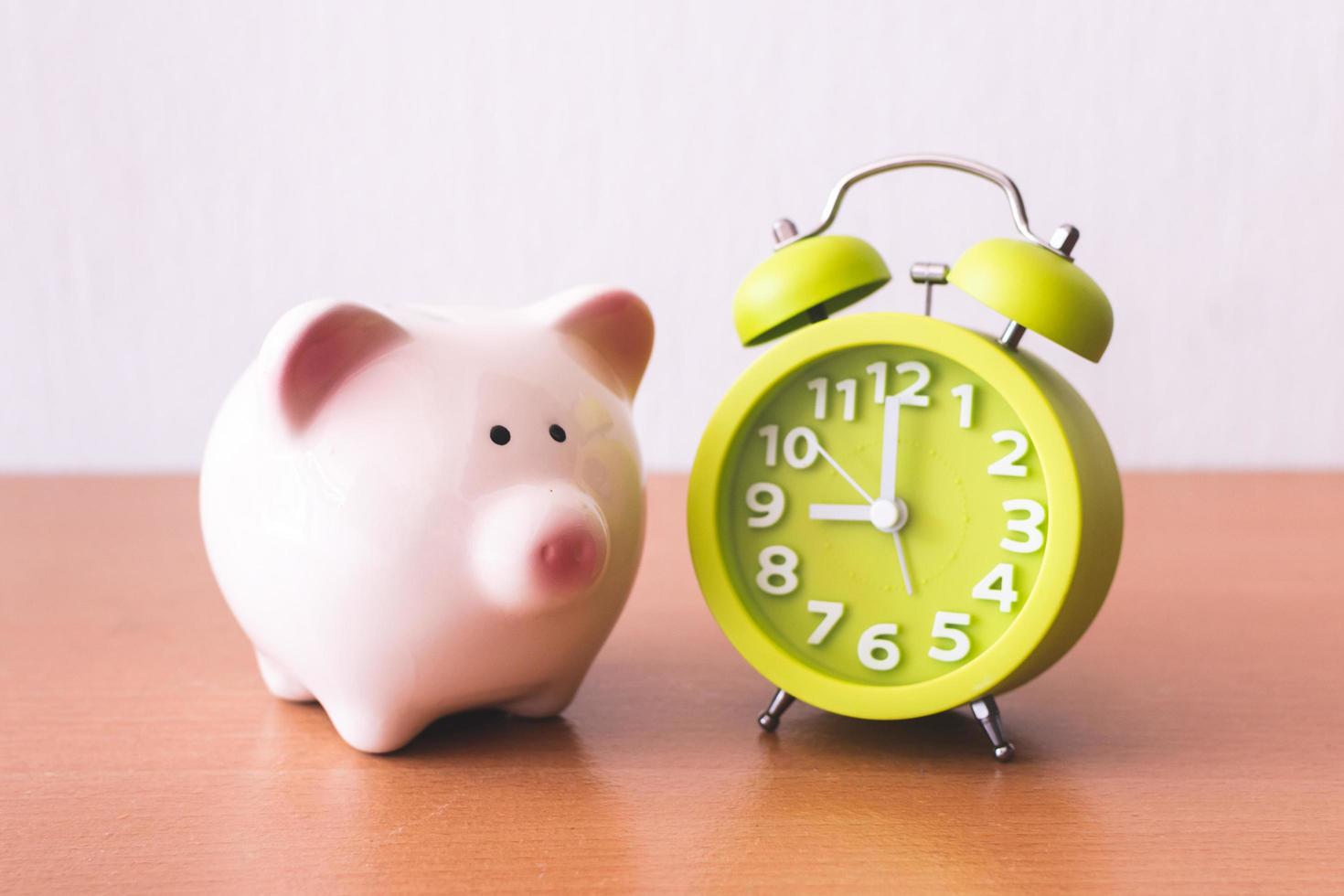 Piggy bank, alarm clock and coins. for growing business. time to saving concept. photo