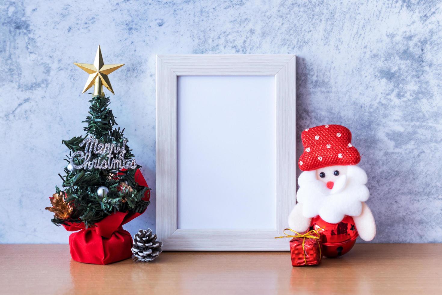 Picture frame and Christmas decoration - Santa Clause and gift on wooden table. Christmas and Happy new year concept photo