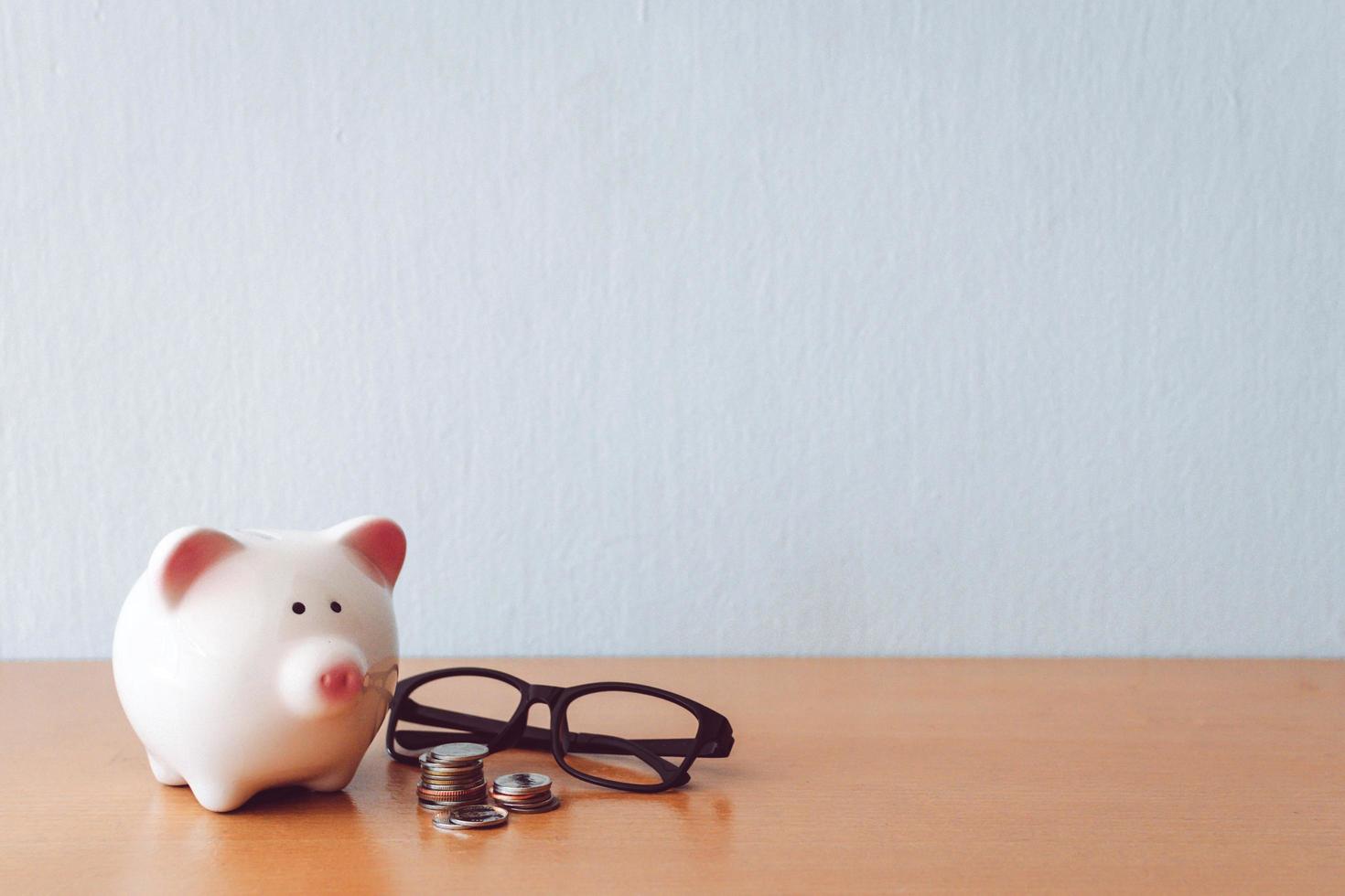 Piggy bank, calculator and coins on Wooden table photo