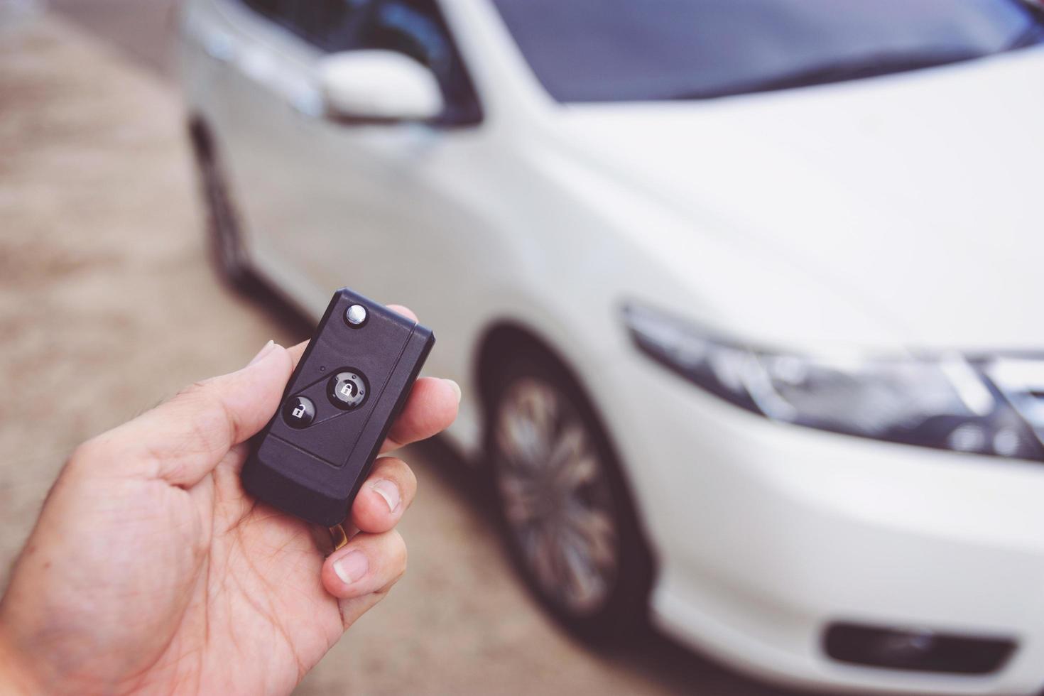 Man holding car keys with car on background photo