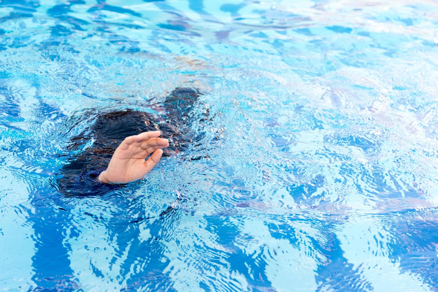 Young boy drowning in the pool photo