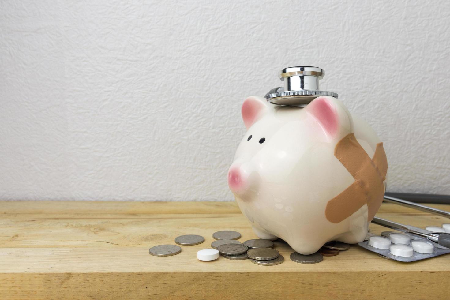 stethoscope with pink piggy bank and coins photo