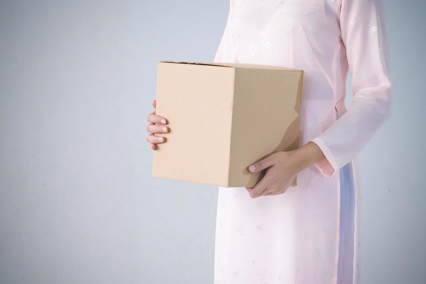 beautiful woman in pink dress and vietnam hat holding box photo