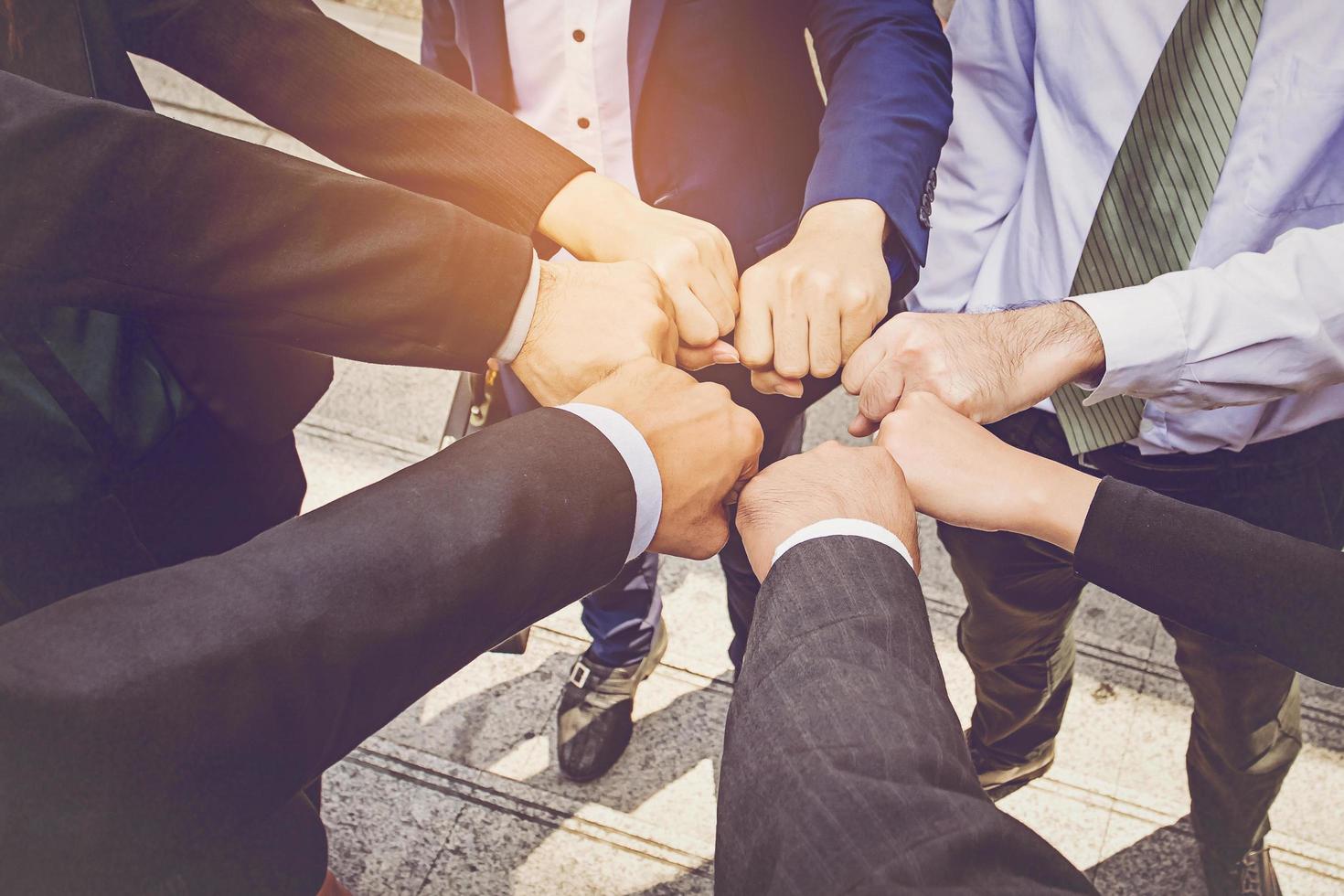 Businesspeople hands in fists in circle, business and teamwork concept photo