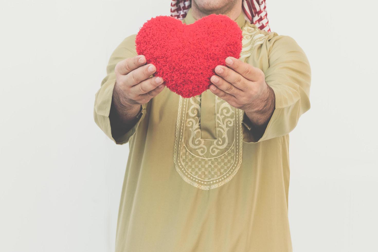 Arab businessman holds a red heart photo