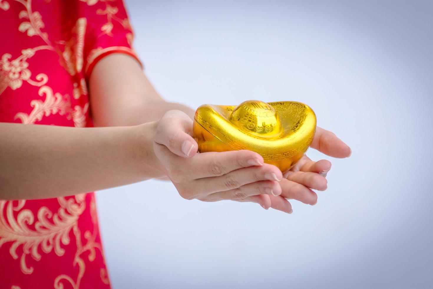 Asian woman with cheongsam holding gold. Chinese new year. photo