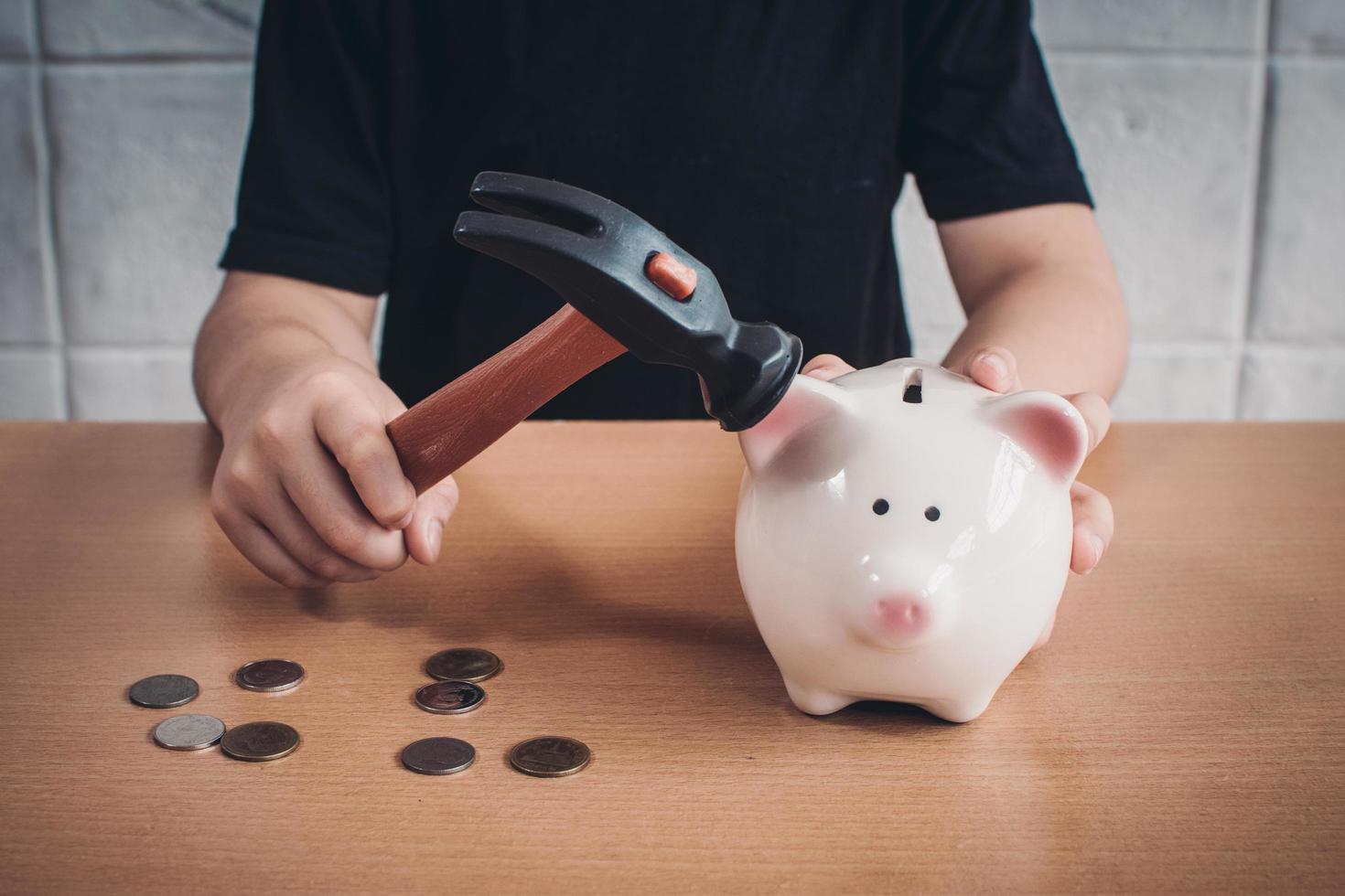 Little boy breaking a piggy bank photo