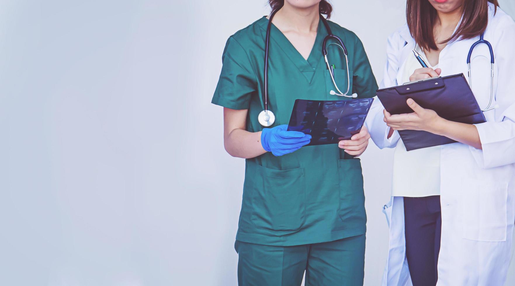 doctor and nurse checking patient information on a tablet device photo