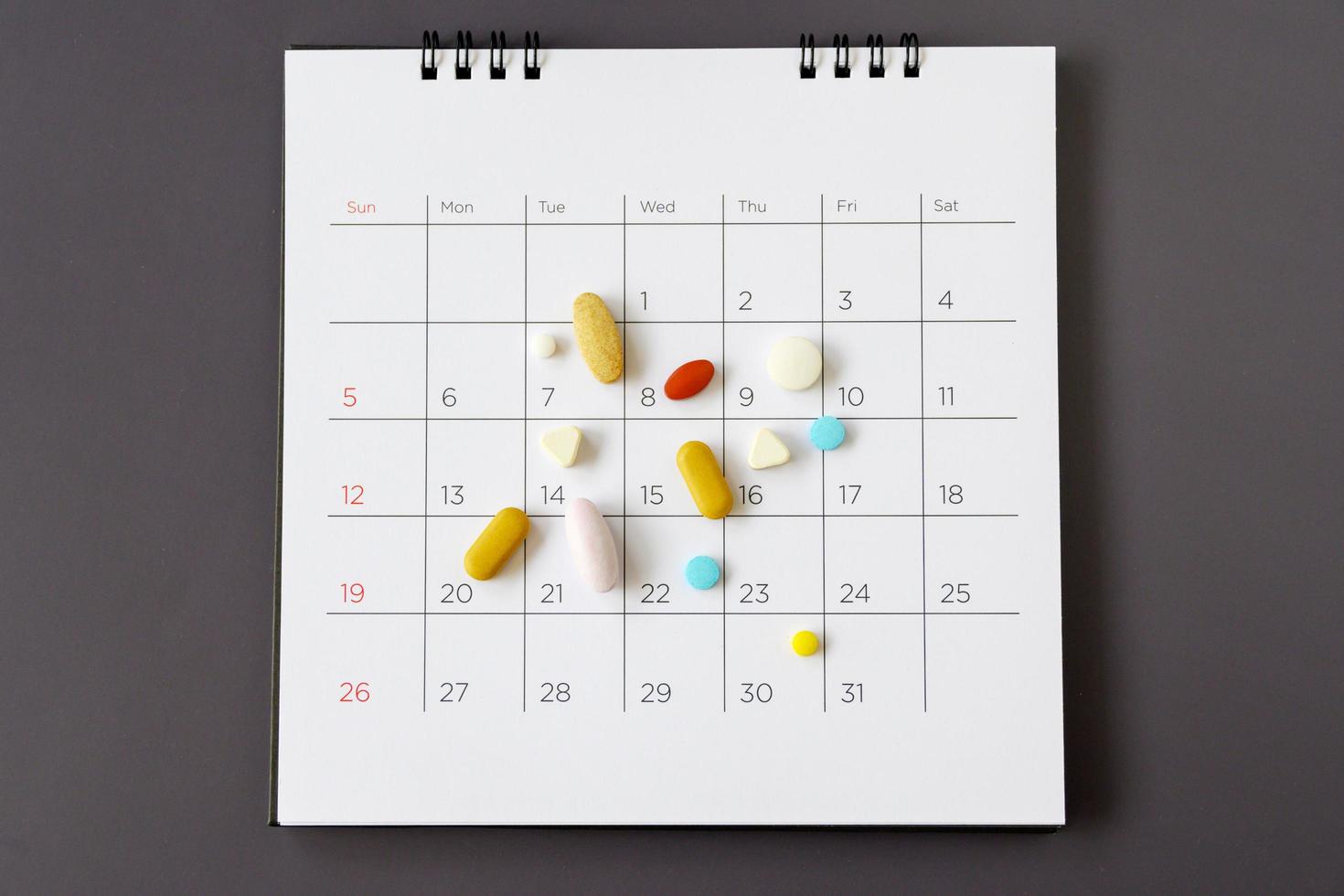 pastillas sobre un fondo de calendario. concepto de salud foto