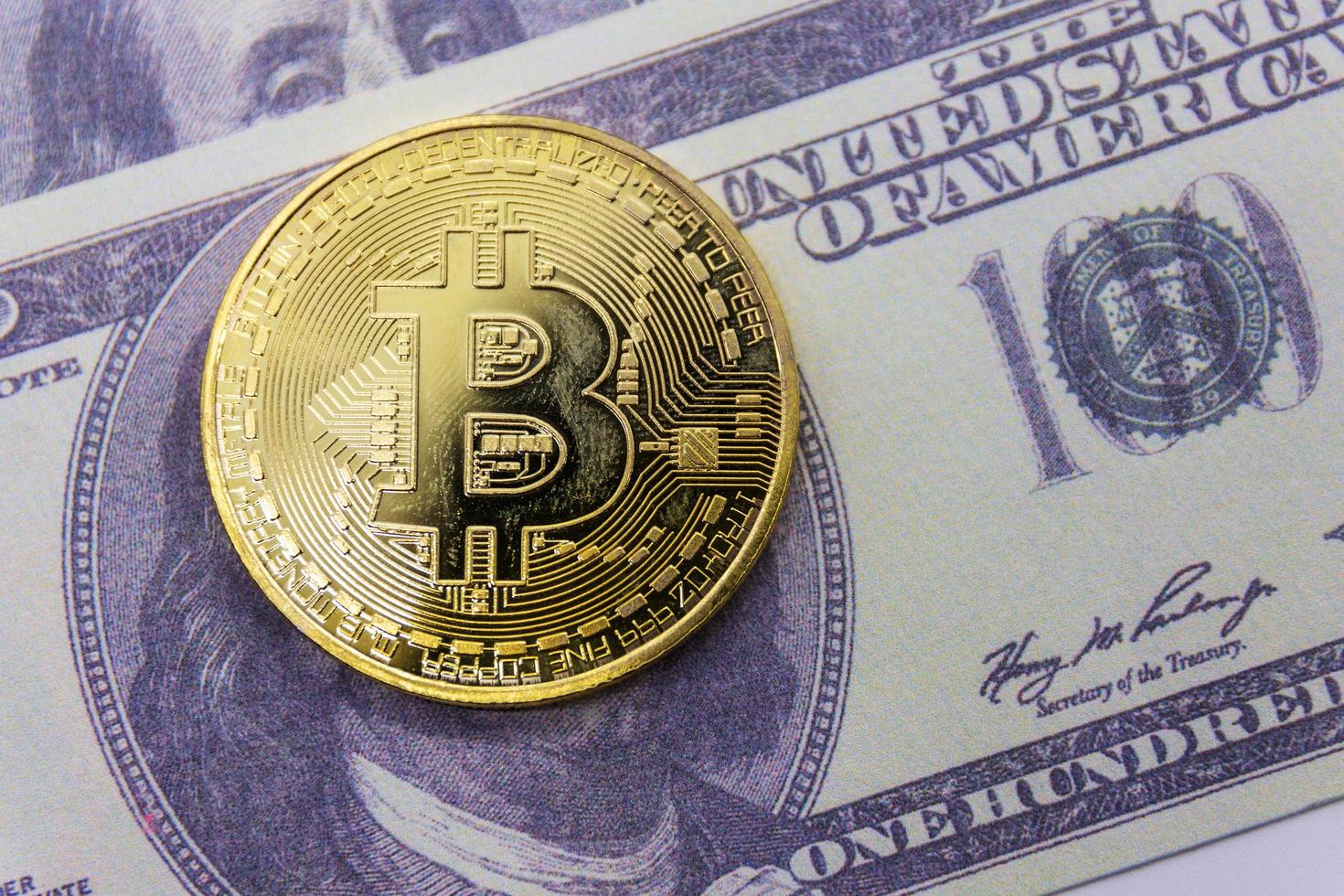 Golden bitcoin coin on us dollars photo