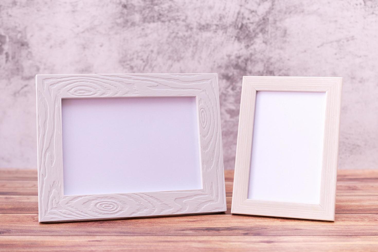 Two Picture frame on wall background and wooden table. Poster product design styled photo