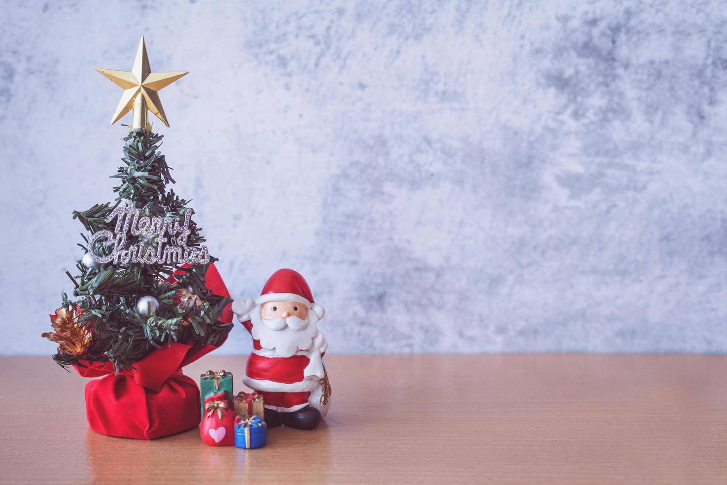 Christmas decoration - Santa Clause, tree and gift on wooden table. Christmas and Happy new year concept photo