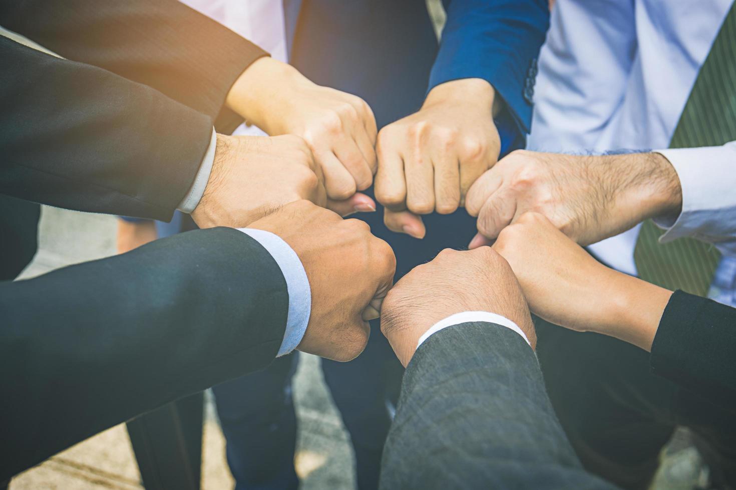 Businesspeople hands in fists in circle, business and teamwork concept photo