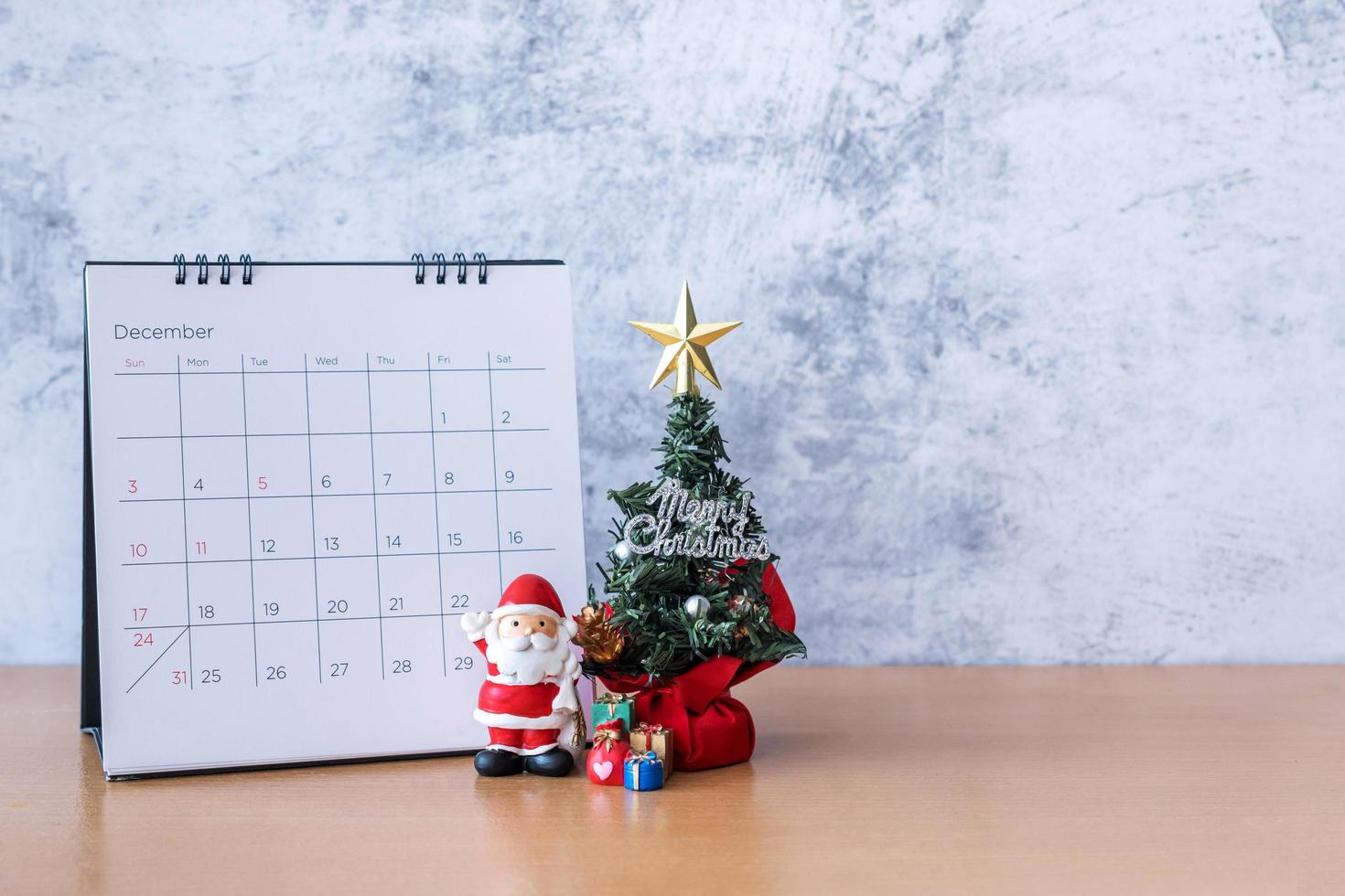 December calendar and Christmas decoration - Santa Clause, tree and gift on wooden table. Christmas and Happy new year concept photo