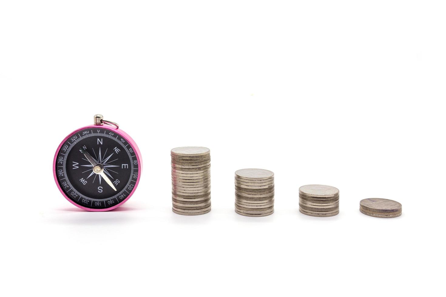 compass and coins on white background photo