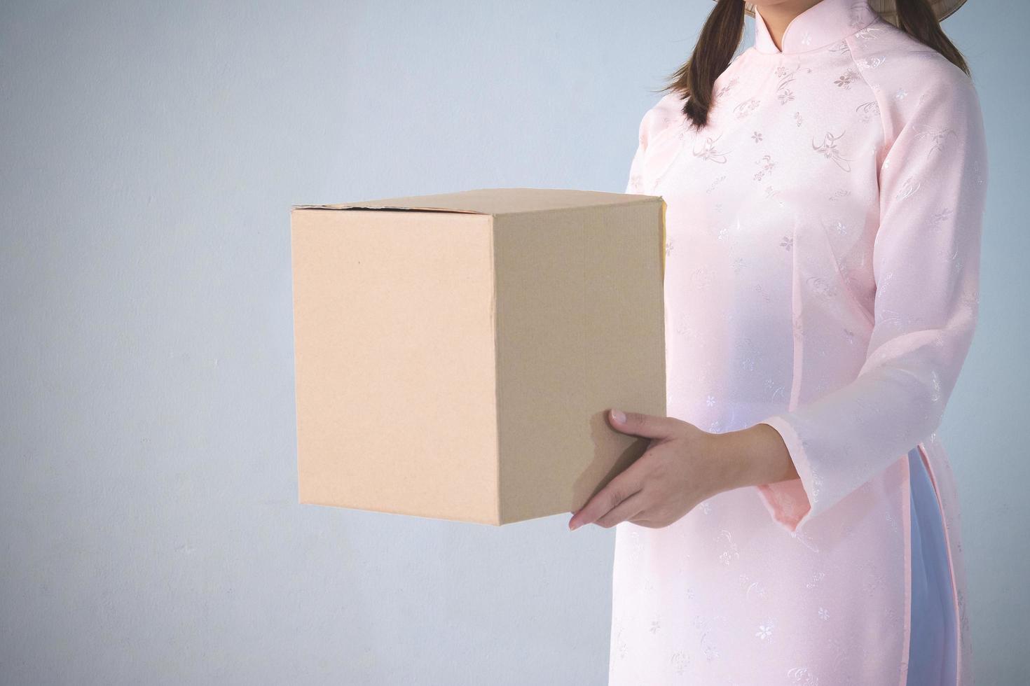 beautiful woman in pink dress and vietnam hat holding box photo